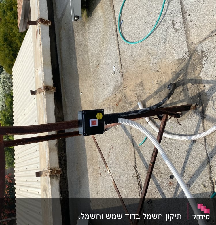 כבלים חשמליים ומתג על עמוד מתכת חלוד